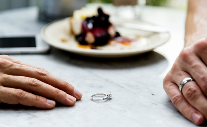 Wedding ring on a table between two hands, symbolizing an attempted manipulation called bluff. Wedding ring on a table between two hands, symbolizing an attempted manipulation called bluff.