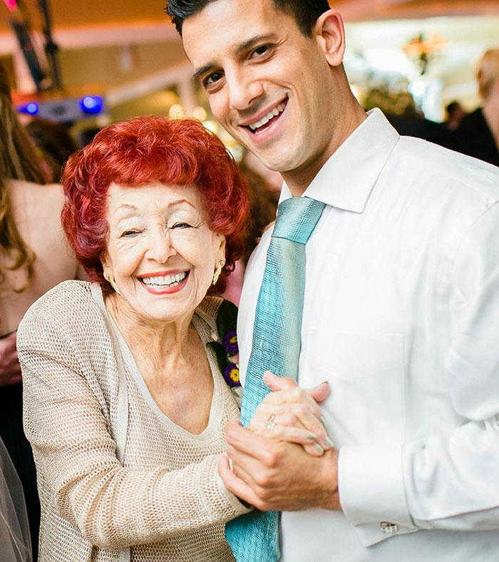 A man smiling as he dances with an elderly woman, both looking happy and enjoying the moment together. A man smiling as he dances with an elderly woman, both looking happy and enjoying the moment together.