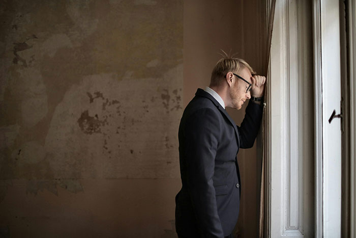 A man in a suit looking shocked, standing by a window, pondering an unexpected event related to wife and twins. A man in a suit looking shocked, standing by a window, pondering an unexpected event related to wife and twins.