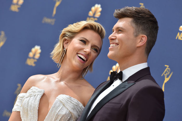 Scarlett Johansson and her husband, Colin Jost, smiling together on the red carpet at an awards event, dressed in formal attire. Scarlett Johansson and her husband, Colin Jost, smiling together on the red carpet at an awards event, dressed in formal attire.