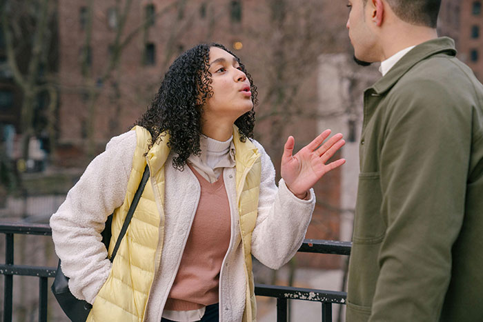 Woman argues with a man outdoors, gesturing passionately, relating to a name change and nanny discussion. Woman argues with a man outdoors, gesturing passionately, relating to a name change and nanny discussion.