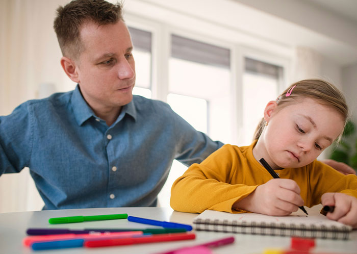 Man watches child drawing with markers, reflecting on kids' behavior near a private pond. Man watches child drawing with markers, reflecting on kids' behavior near a private pond.