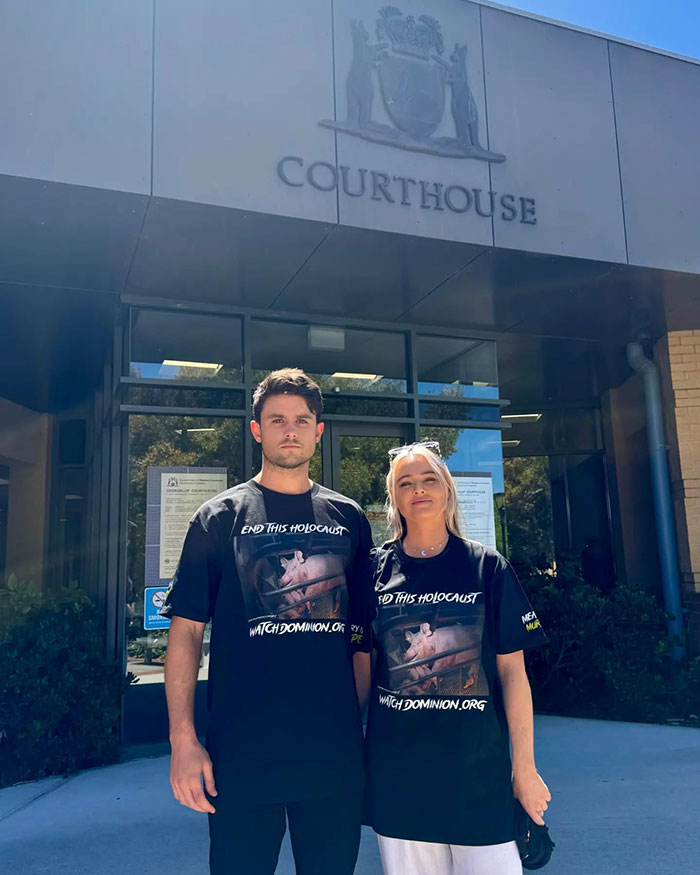 Vegan activist couple stands outside courthouse advocating against animal slavery. Vegan activist couple stands outside courthouse advocating against animal slavery.