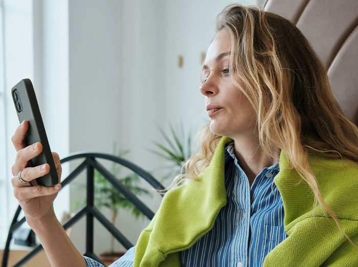 Woman looking at her phone, contemplating a past experience related to cheating and exposure. Woman looking at her phone, contemplating a past experience related to cheating and exposure.