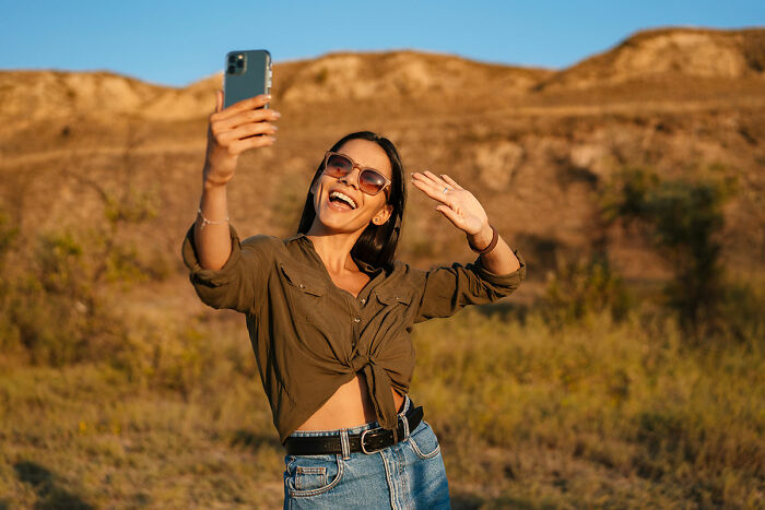 Woman taking a selfie in sunglasses and casual attire outdoors, related to daughters' exotic trip. Woman taking a selfie in sunglasses and casual attire outdoors, related to daughters' exotic trip.