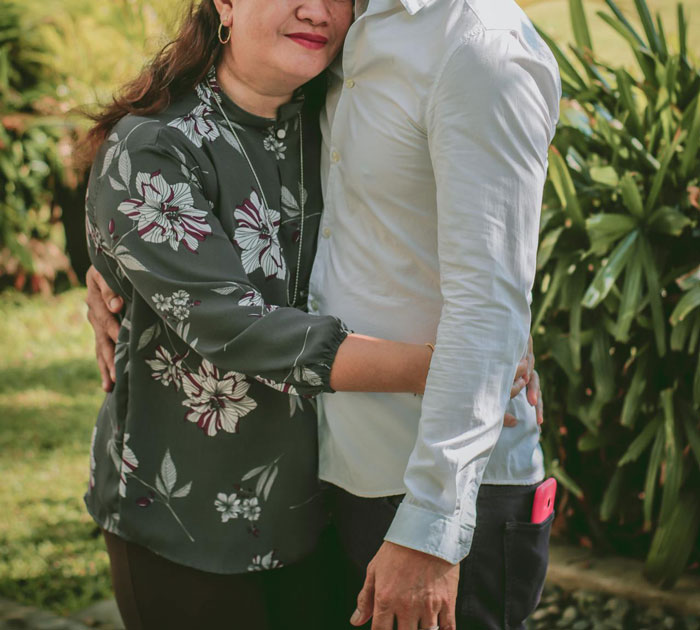 A woman and man embracing outdoors, symbolizing family conflict and resolution. A woman and man embracing outdoors, symbolizing family conflict and resolution.