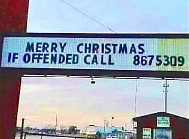 Weird and absurd sign reads "Merry Christmas. If offended call 8675309" in an outdoor setting.