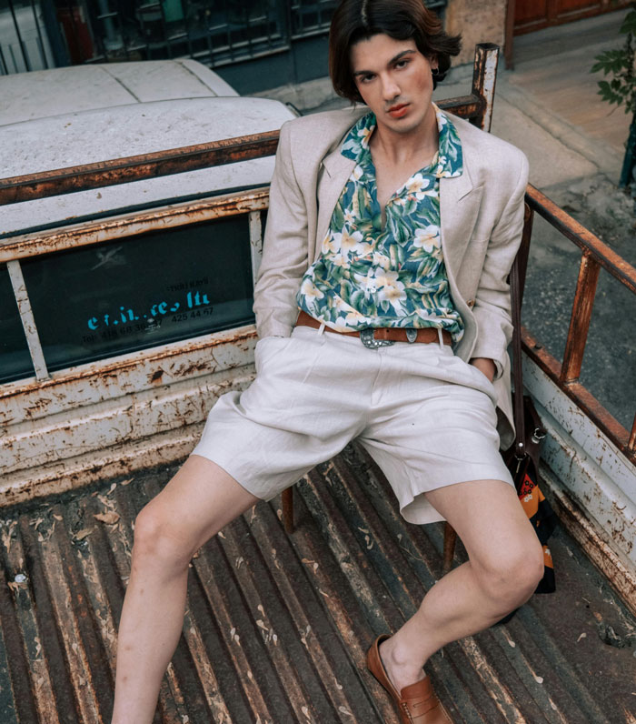 Person wearing a floral shirt, beige blazer, and shorts, exemplifying a criticized fashion trend.