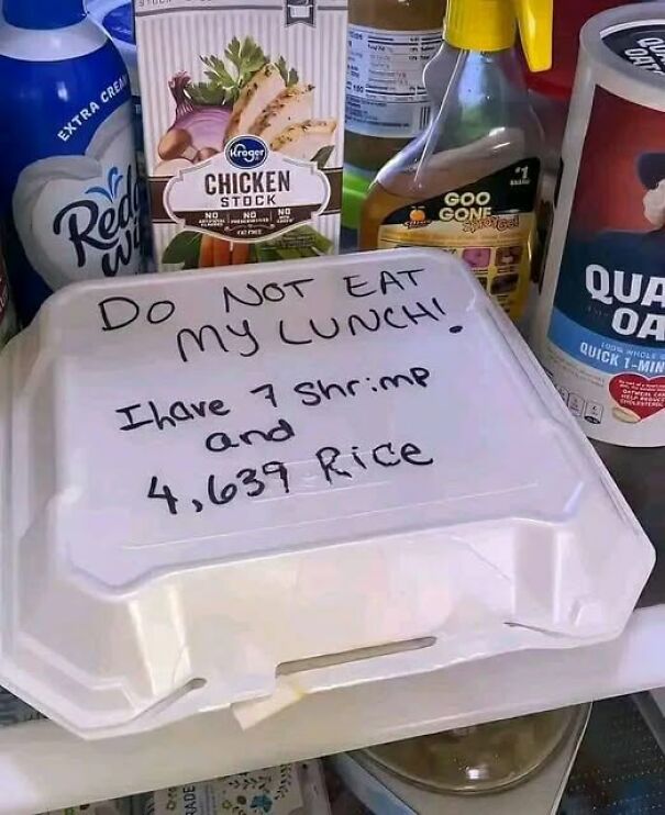 Takeout box with a handwritten note: "Do not eat my lunch! I have 7 shrimp and 4,639 rice" surrounded by kitchen items.