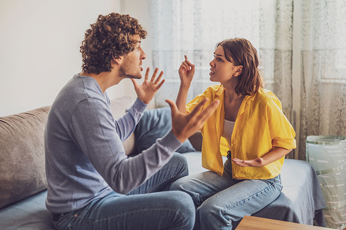 Couple arguing in living room, expressing frustration and upset emotions. Couple arguing in living room, expressing frustration and upset emotions.