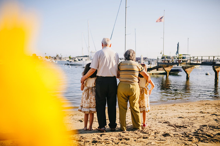 Elderly couple and children facing the ocean during an unexpected family vacation gathering. Elderly couple and children facing the ocean during an unexpected family vacation gathering.