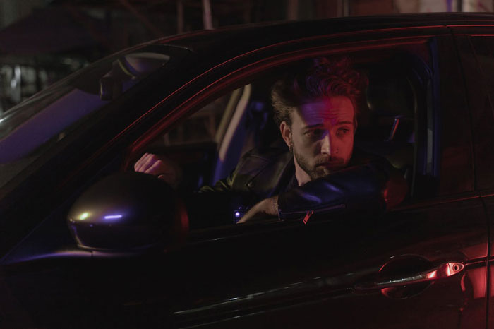 Man sitting in a car at night, looking pensive after a date. Man sitting in a car at night, looking pensive after a date.