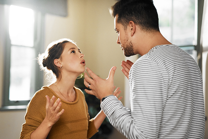 A dad babysits, appearing frustrated, while having a discussion with a woman in a cozy room setting. A dad babysits, appearing frustrated, while having a discussion with a woman in a cozy room setting.