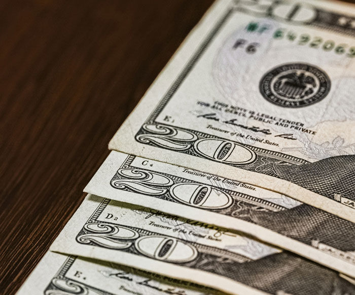 Dollar bills laid on a table symbolizing a surprise gift that went wrong. Dollar bills laid on a table symbolizing a surprise gift that went wrong.