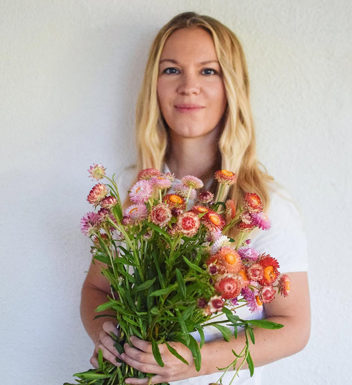 Jenna Miscavige holding colorful flowers against a plain background, related to ex-Scientologist discussions. Jenna Miscavige holding colorful flowers against a plain background, related to ex-Scientologist discussions.
