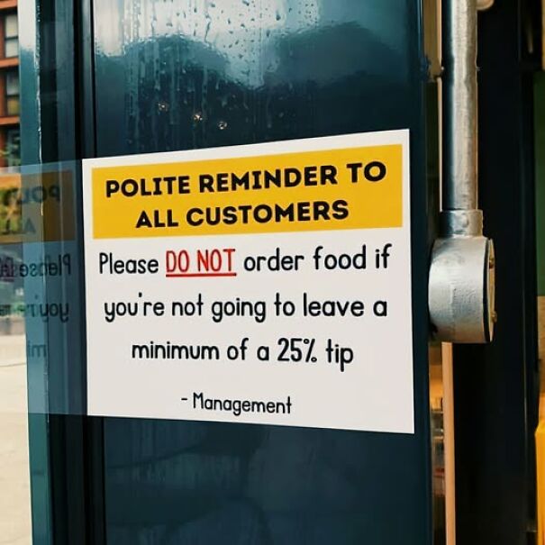 Weird and absurd sign in a restaurant window reminding customers to tip at least 25%.