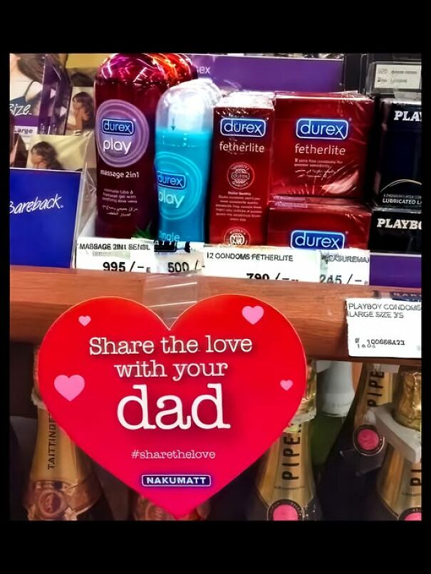 Weird and absurd sign in a store promoting "Share the love with your dad" over condoms and champagne.