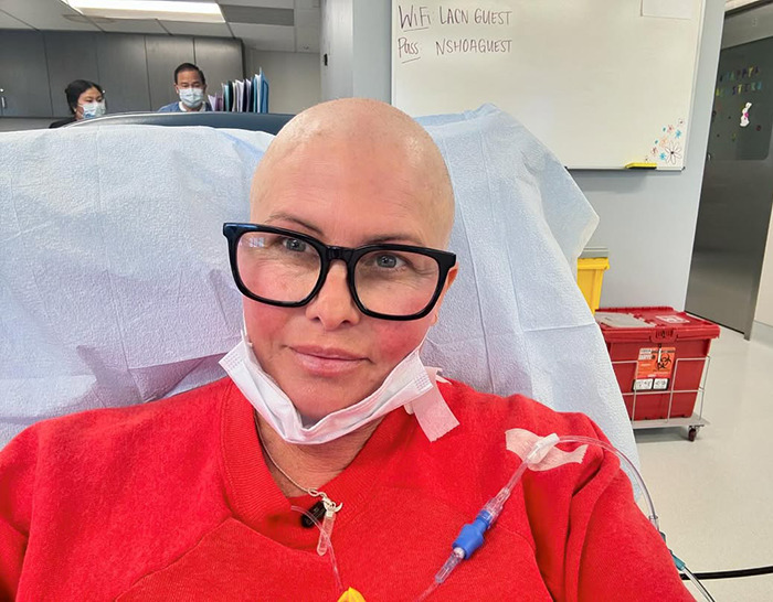 Nicole Eggert in hospital, wearing glasses and a red sweater. Nicole Eggert in hospital, wearing glasses and a red sweater.