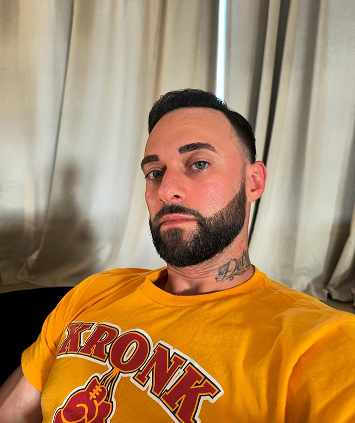 Man in a yellow shirt sitting indoors, appearing thoughtful. Man in a yellow shirt sitting indoors, appearing thoughtful.