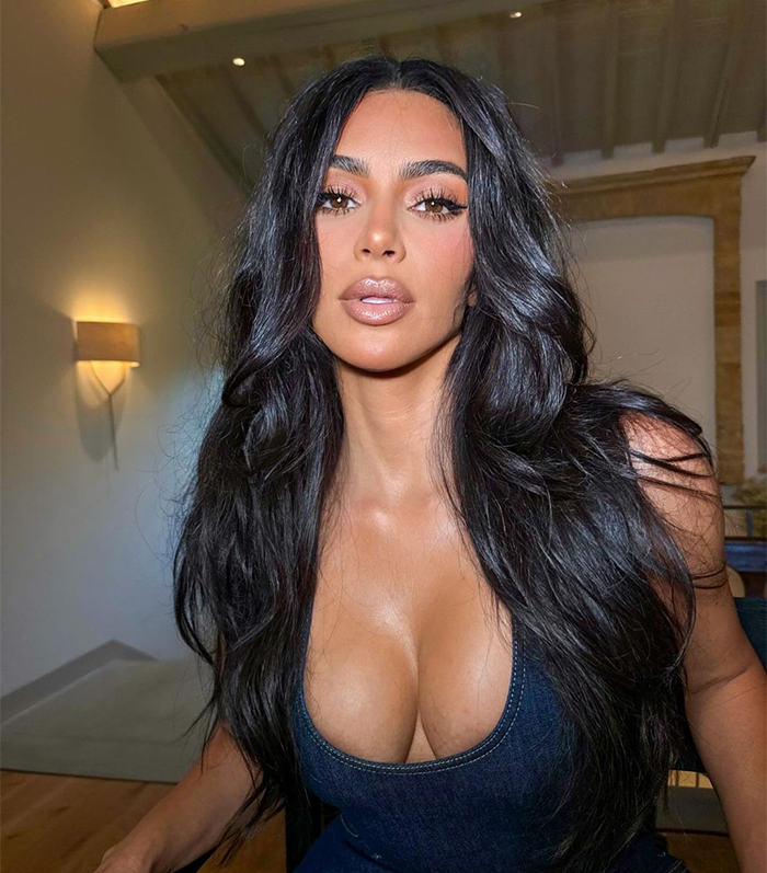 Kim Kardashian in a denim top with long hair and neutral makeup in a well-lit room. Kim Kardashian in a denim top with long hair and neutral makeup in a well-lit room.