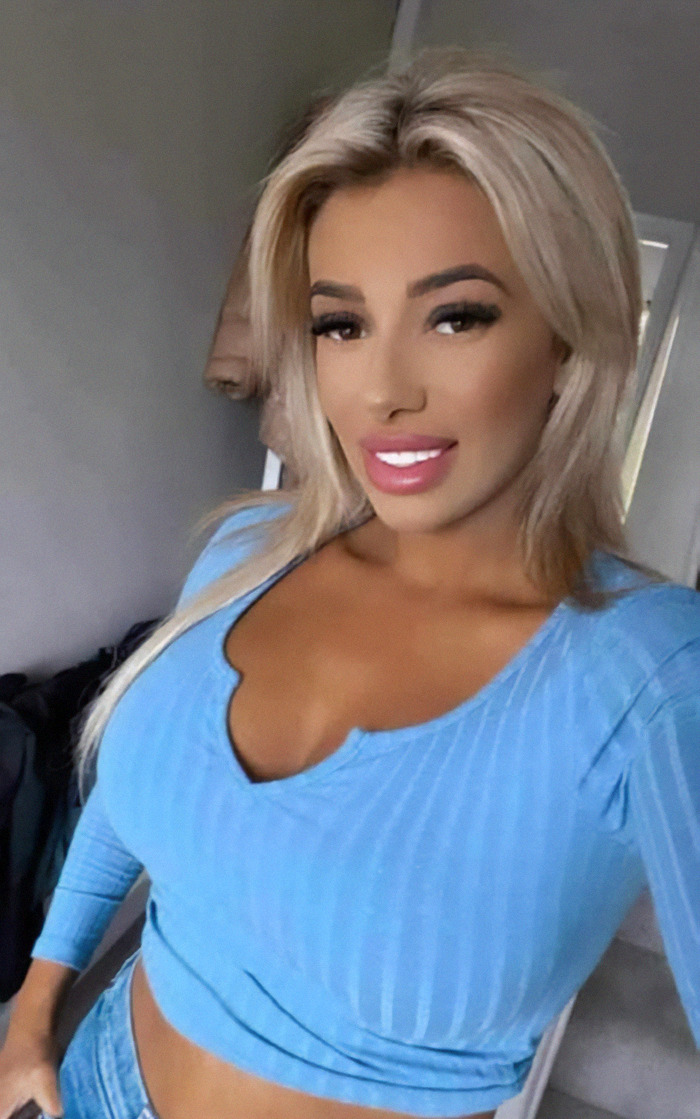 Demi Agoglia in a blue top smiling at the camera, related to BBL surgery incident. Demi Agoglia in a blue top smiling at the camera, related to BBL surgery incident.