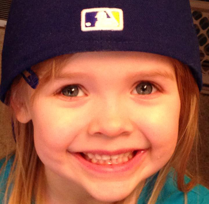 Young Natalie Rupnow smiling, wearing a baseball cap. Young Natalie Rupnow smiling, wearing a baseball cap.