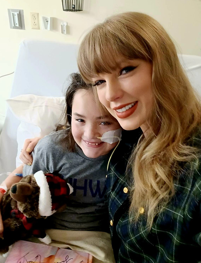 Taylor Swift smiles with a young patient in a children's hospital visit. Taylor Swift smiles with a young patient in a children's hospital visit.