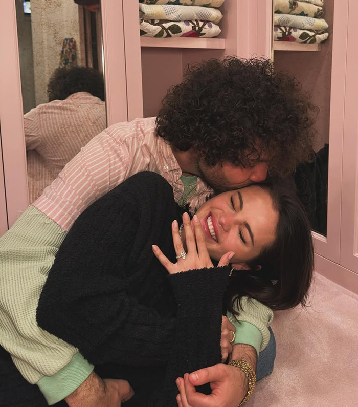 Selena Gomez with engagement ring, embraced by Benny Blanco in cozy setting. Selena Gomez with engagement ring, embraced by Benny Blanco in cozy setting.