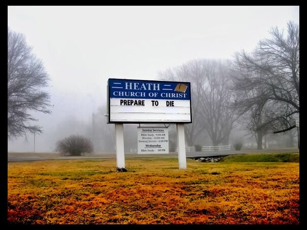 Weird sign outside church reads "Prepare to Die" in a misty setting.