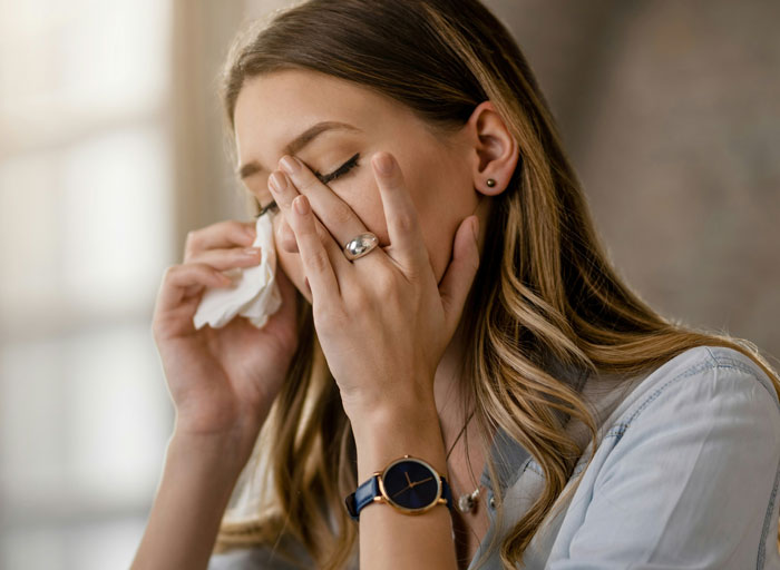Woman crying into tissue, upset about brother-in-law’s drunken behavior, wearing a watch and casual clothing. Woman crying into tissue, upset about brother-in-law’s drunken behavior, wearing a watch and casual clothing.