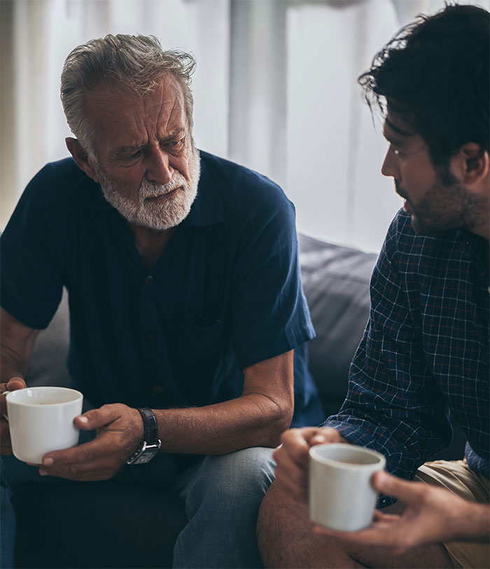 Two men having a serious conversation over coffee about family and ex-partner holiday plans. Two men having a serious conversation over coffee about family and ex-partner holiday plans.