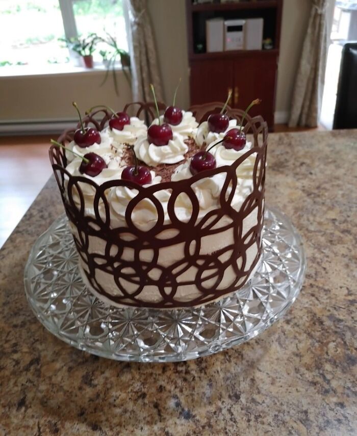 Elegant chocolate and cherry cake on a glass platter, symbolizing thoughtful gifts from amazing mothers-in-law.