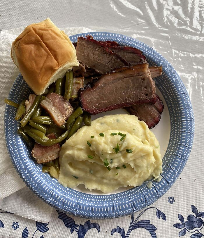 Plate of brisket, green beans, mashed potatoes, and a roll, showcasing a delicious meal, invoking amazing mothers-in-law vibes.