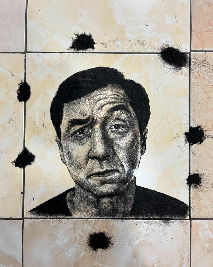 Creative barber's unique portrait made using cut hair on tile floor.
