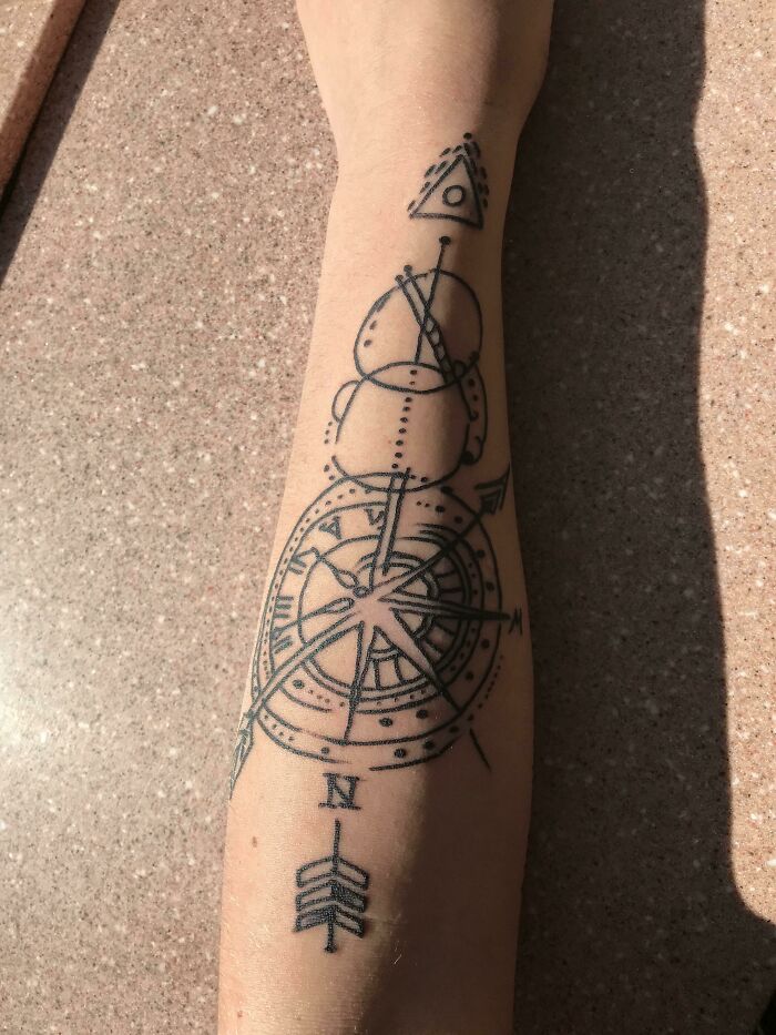Compass tattoo fail with mismatched geometric shapes on a forearm, showcasing tattoo fail humor.