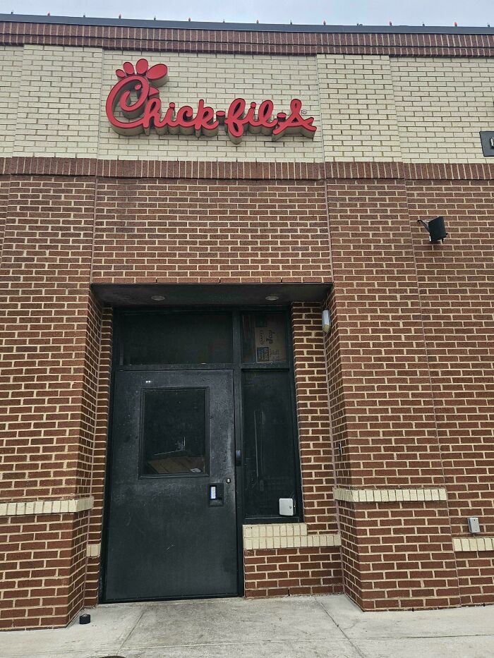 Back entrance of a Chick-fil-A with a black door, illustrating employees blatantly ignoring safety protocol risks.