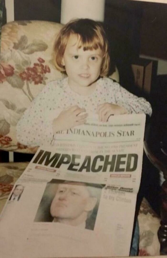 Child holding a newspaper with "Impeached" headline, symbolizing a blunder years memory.