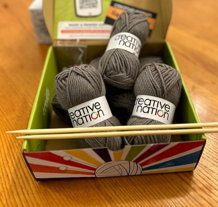 Box of gray yarn and knitting needles, ideal gifts for teachers.