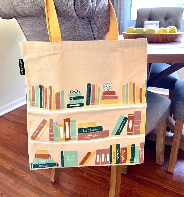 Book-themed tote bag on a wooden chair, perfect gift for teachers.