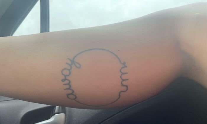 A tattoo with mirrored words "away" forms a circle on an arm; text below reads "run homo instead of run away."