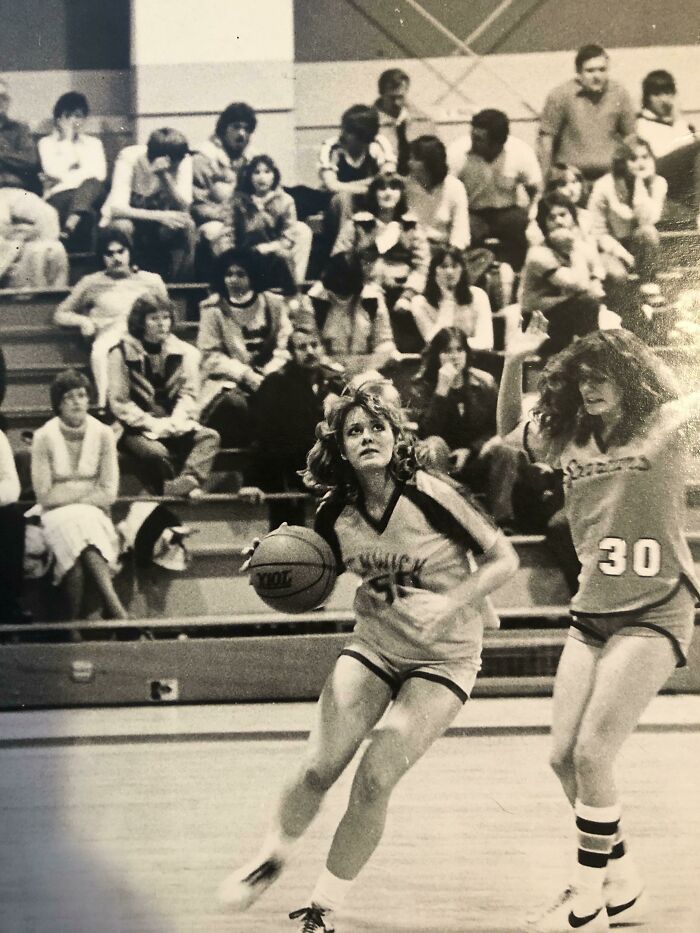 70s high school girls' basketball game with players and crowd in gymnasium. 70s high school girls' basketball game with players and crowd in gymnasium.