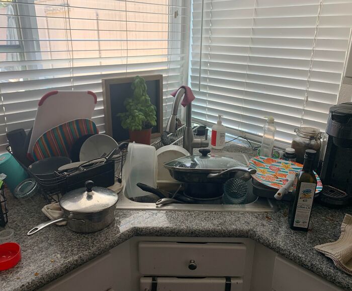 Messy kitchen sink cluttered with dirty dishes and cooking utensils, evoking infuriating family members.