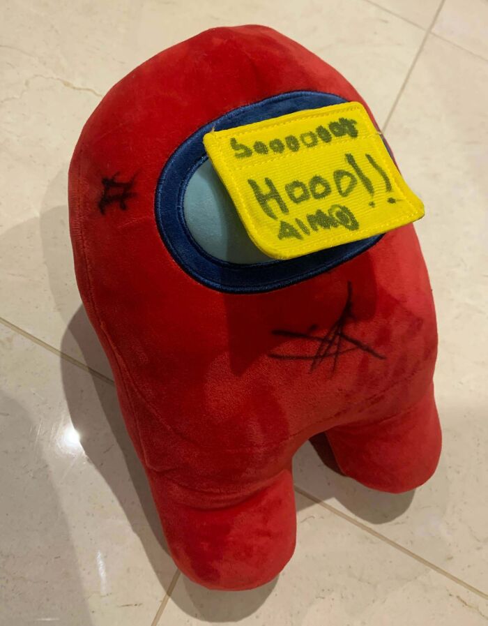 Red plush toy with hand-drawn details and a yellow note on top, humorously linked to infuriating family members.