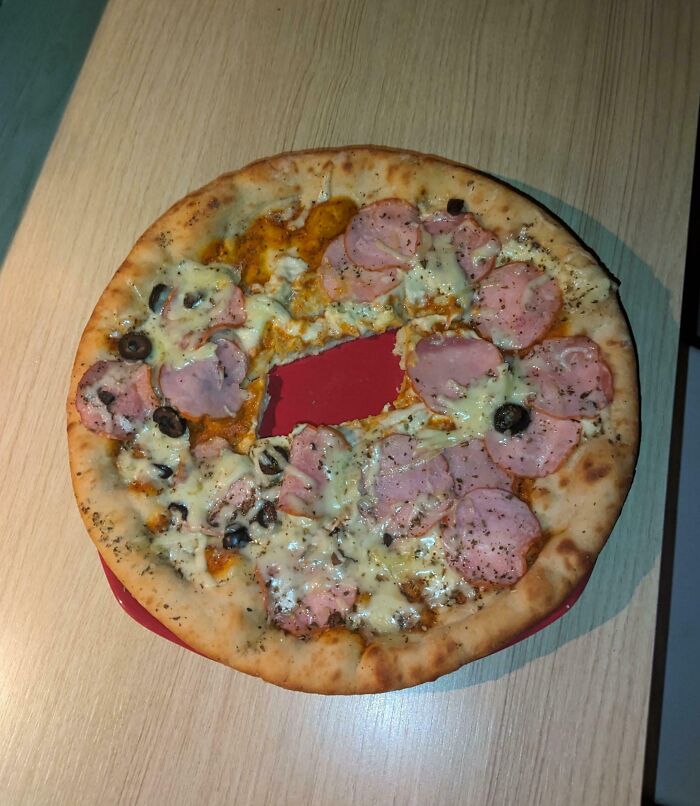 Pizza with a large slice missing, revealing the red plate beneath, illustrating infuriating family members' quirks.