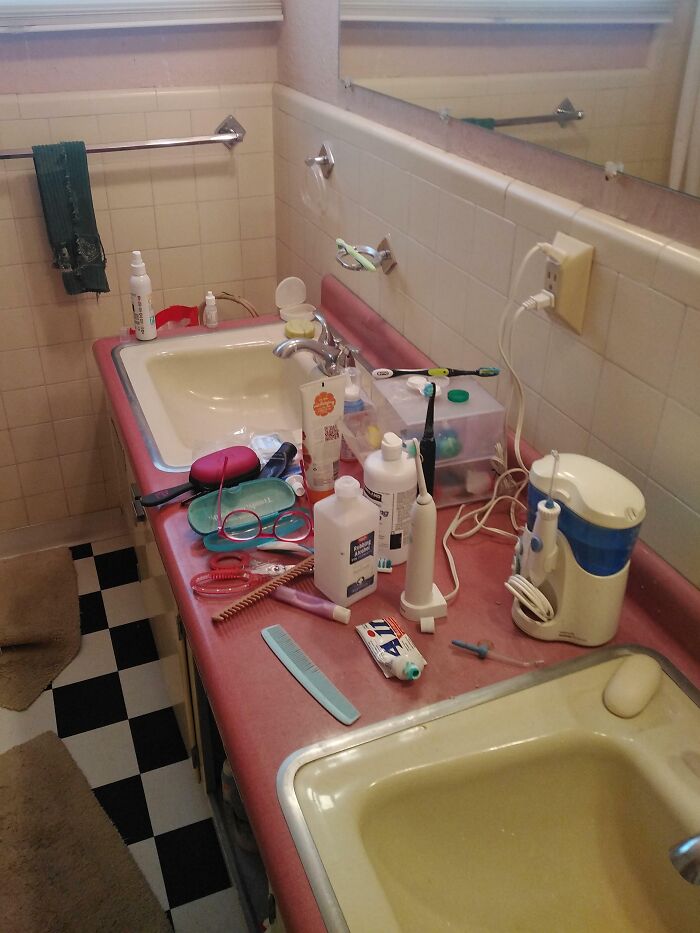 Cluttered bathroom sink with scattered toiletries, showing infuriating family members' mess.