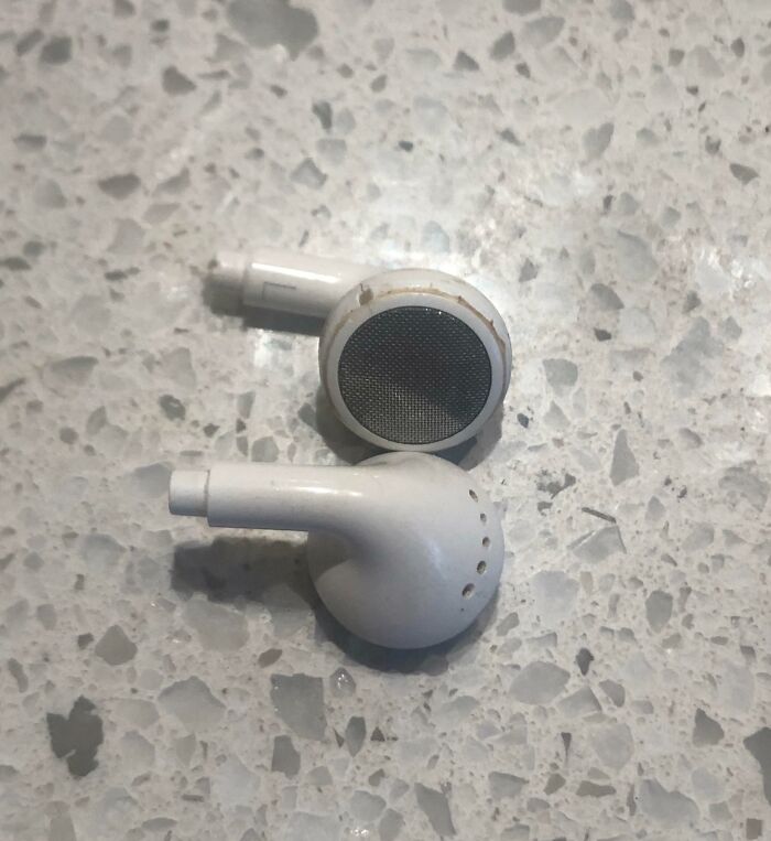 Close-up of broken white earphones on a speckled countertop, symbolizing infuriating family members.
