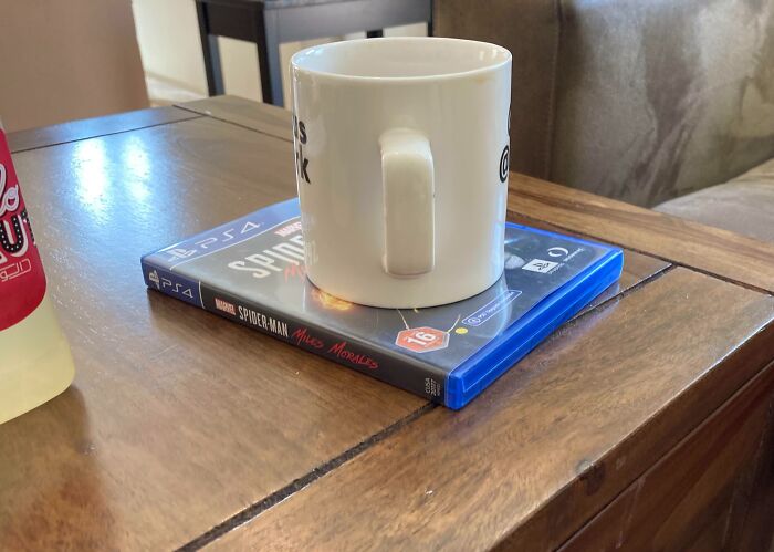 Mug placed on a PS4 game case on a table, representing infuriating family habits.