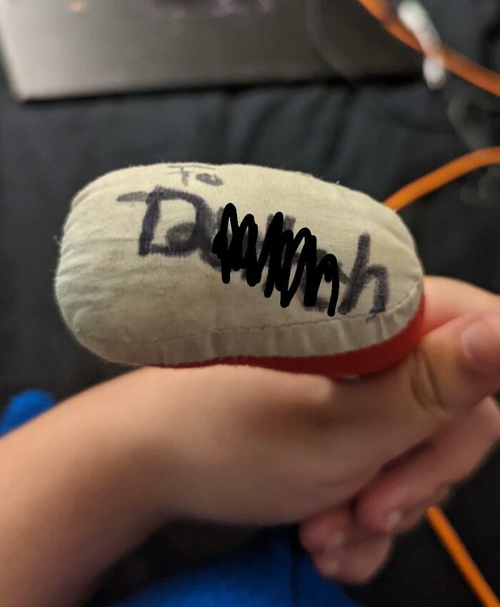Child holding a plush toy scribbled with an unclear message, symbolizing infuriating family members.