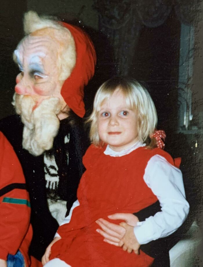 Child sitting on a person's lap dressed as creepy Santa with a red hood and mask. Child sitting on a person's lap dressed as creepy Santa with a red hood and mask.