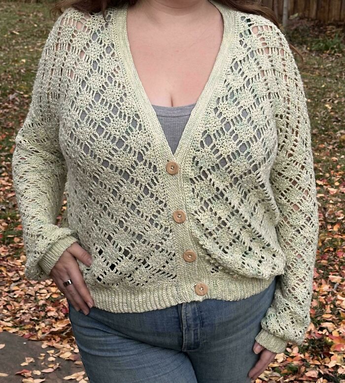 Handmade crochet cardigan with wooden buttons worn outdoors, showcasing a proud crochet enthusiast's detailed project.